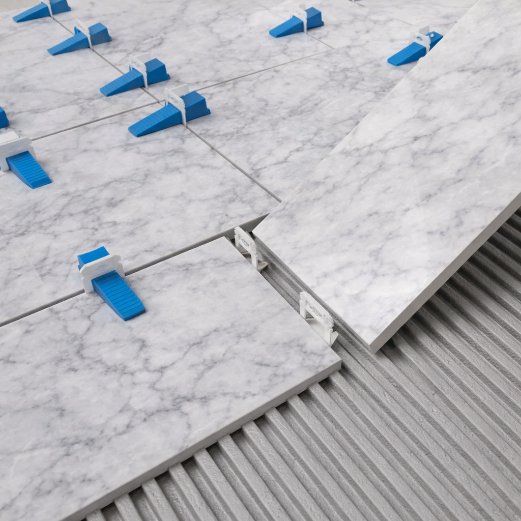 Tile installer using the Lahvel leveling clip system on a professional floor installation